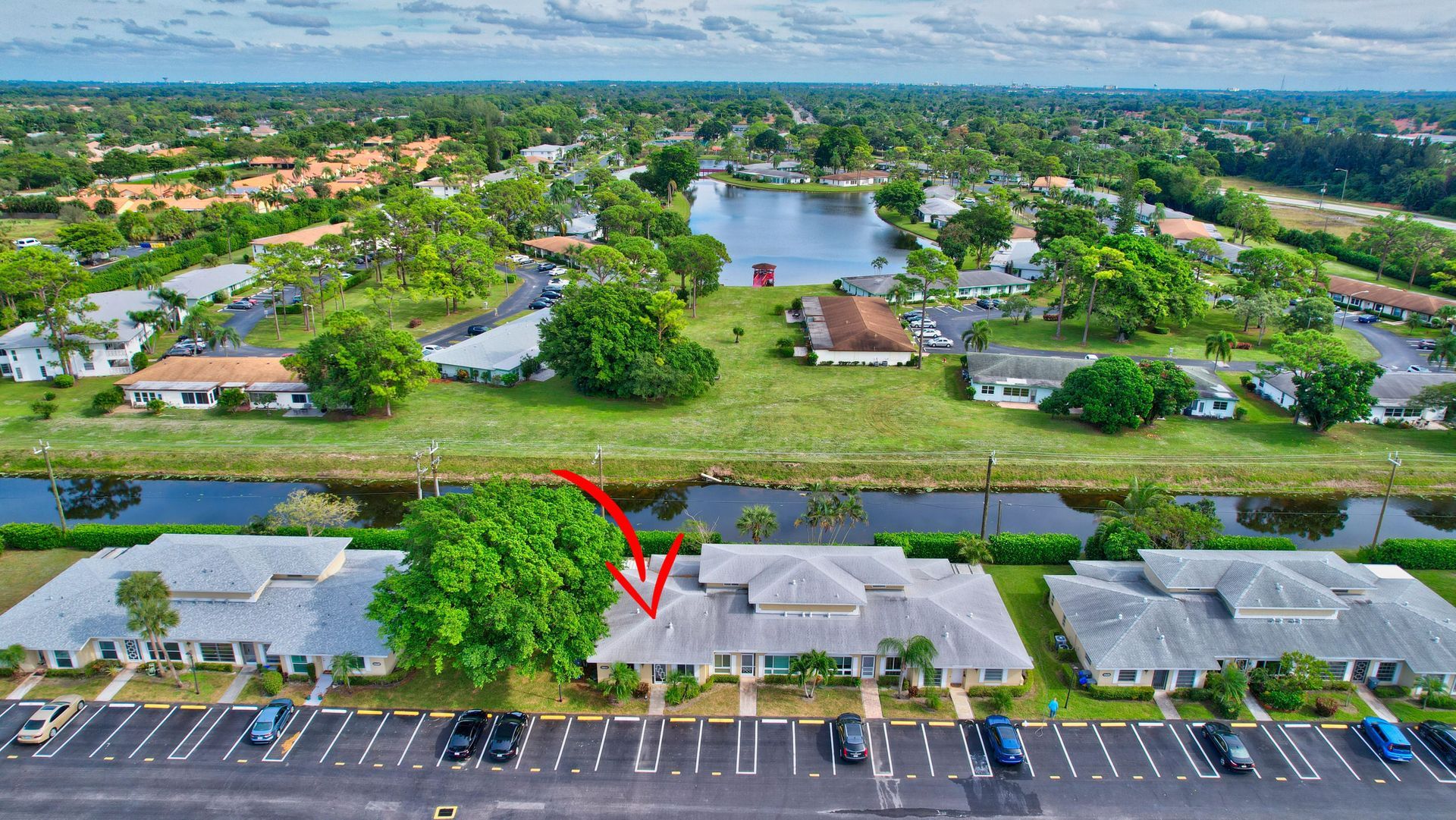 An aerial view of a residential area with a red arrow pointing to a house.