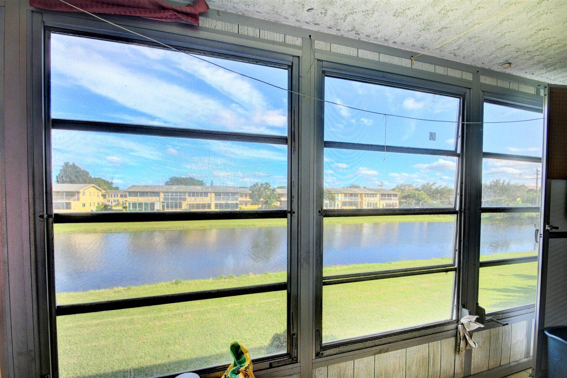 A room with a lot of windows and a view of a lake.