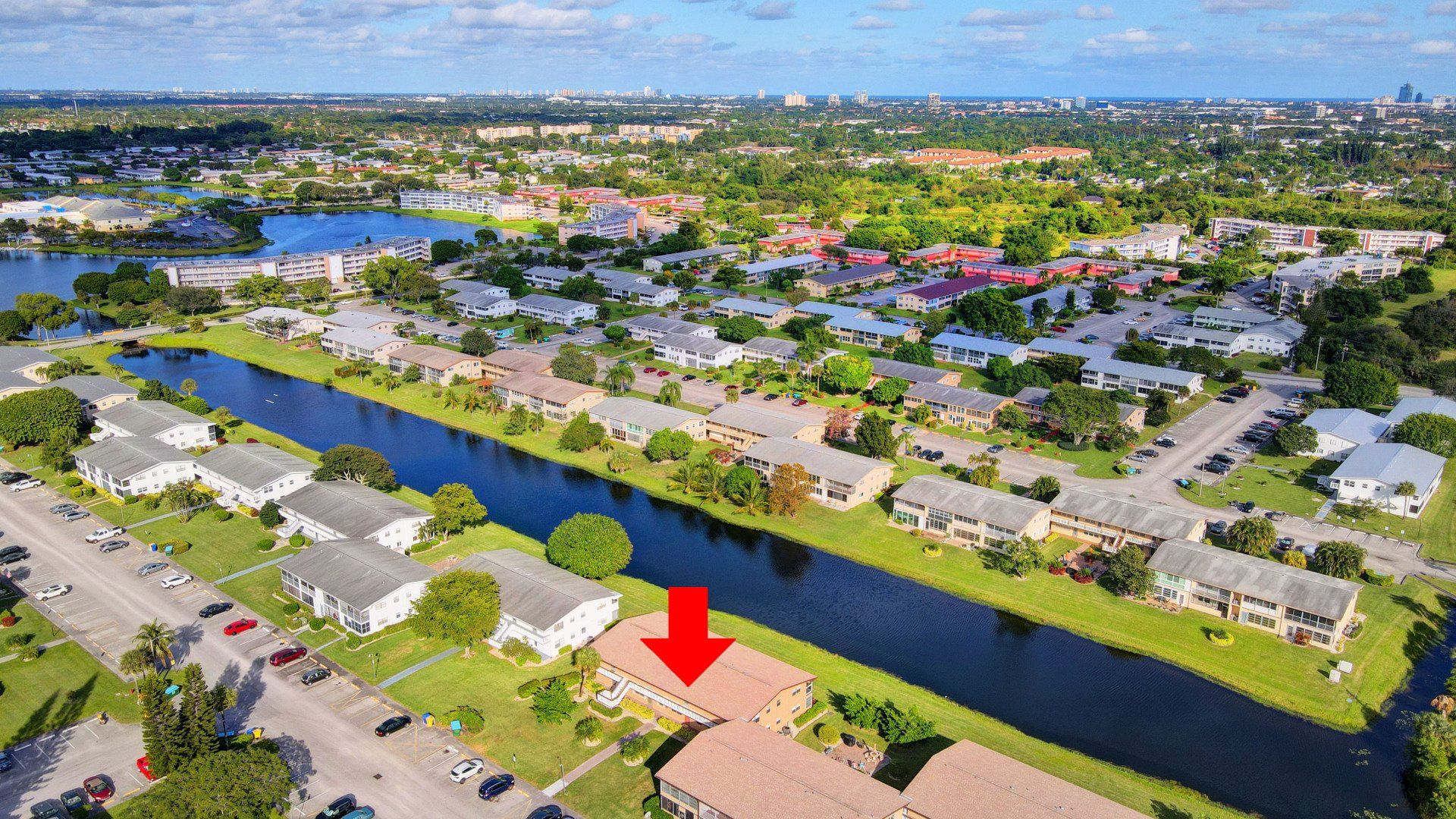 An aerial view of a residential area with a red arrow pointing to a building.