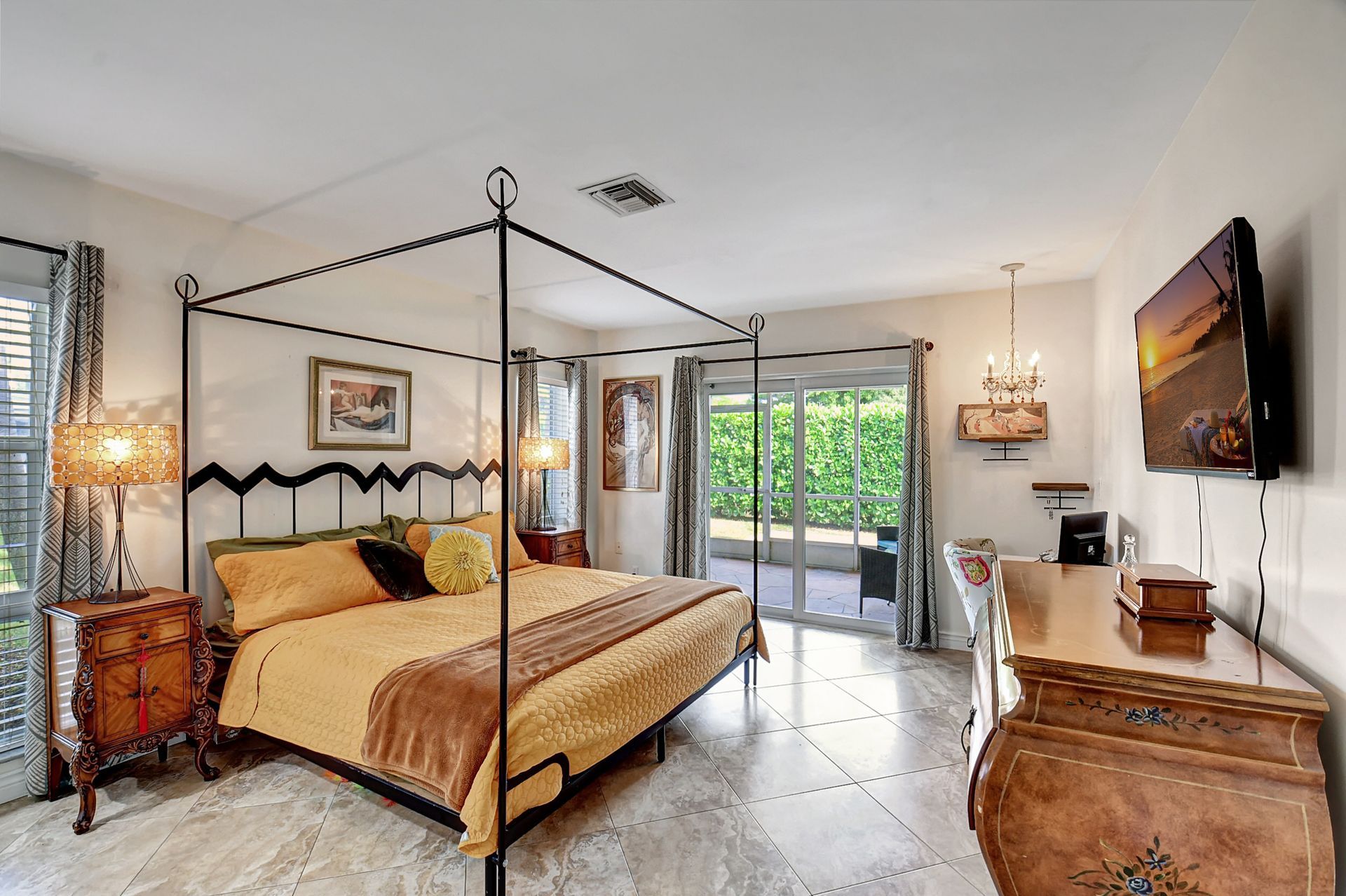 A bedroom with a four poster bed and a flat screen tv.