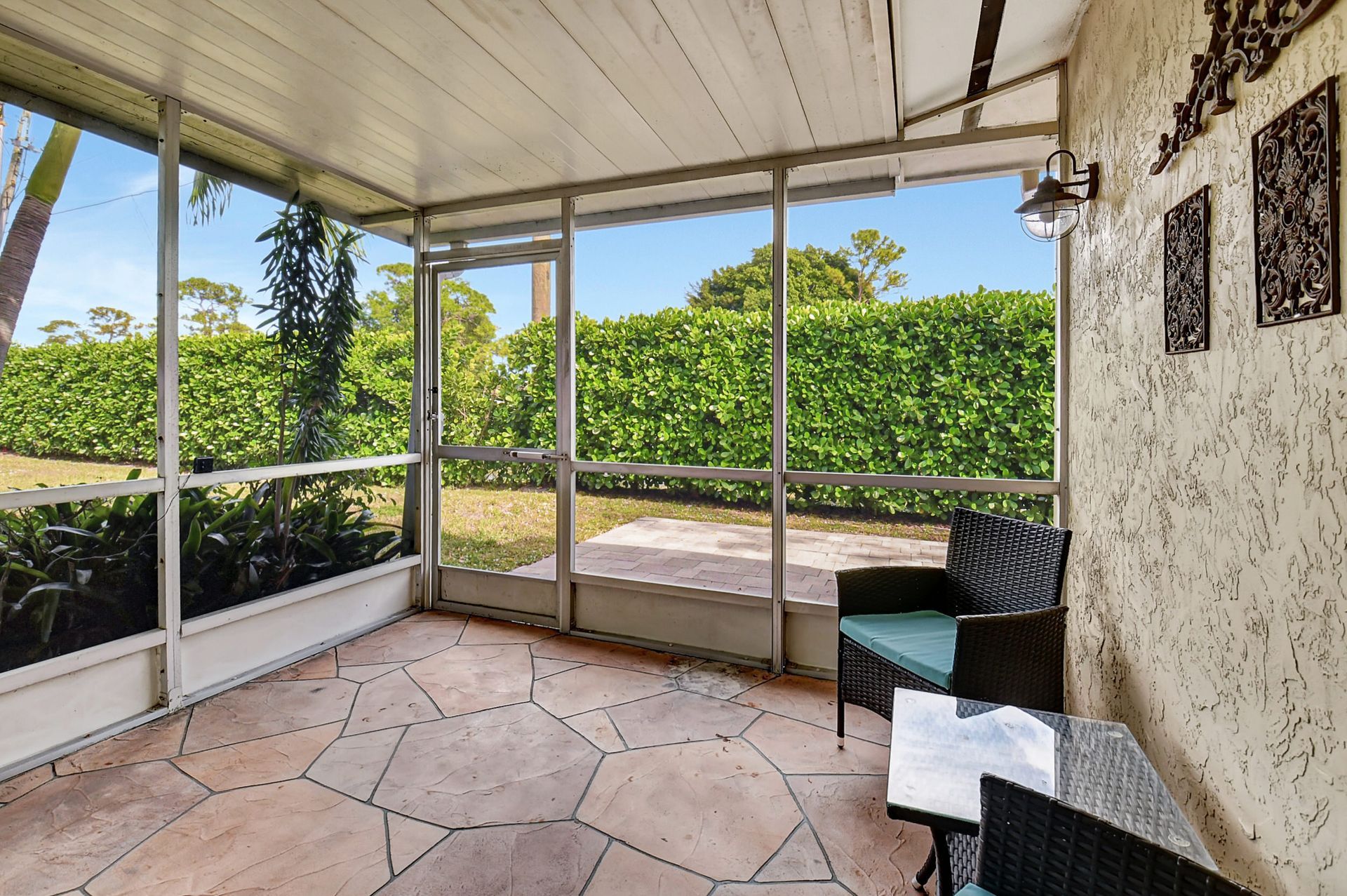 A screened in porch with a chair and a table