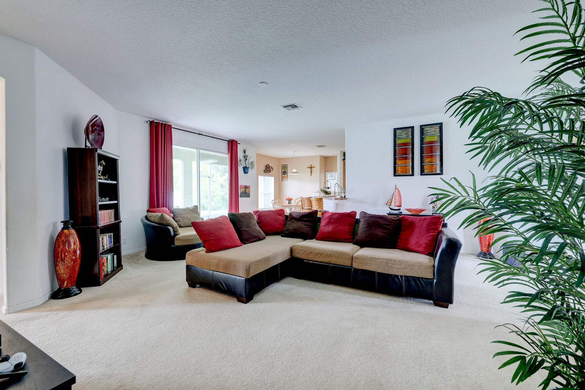A living room with a sectional couch and a plant