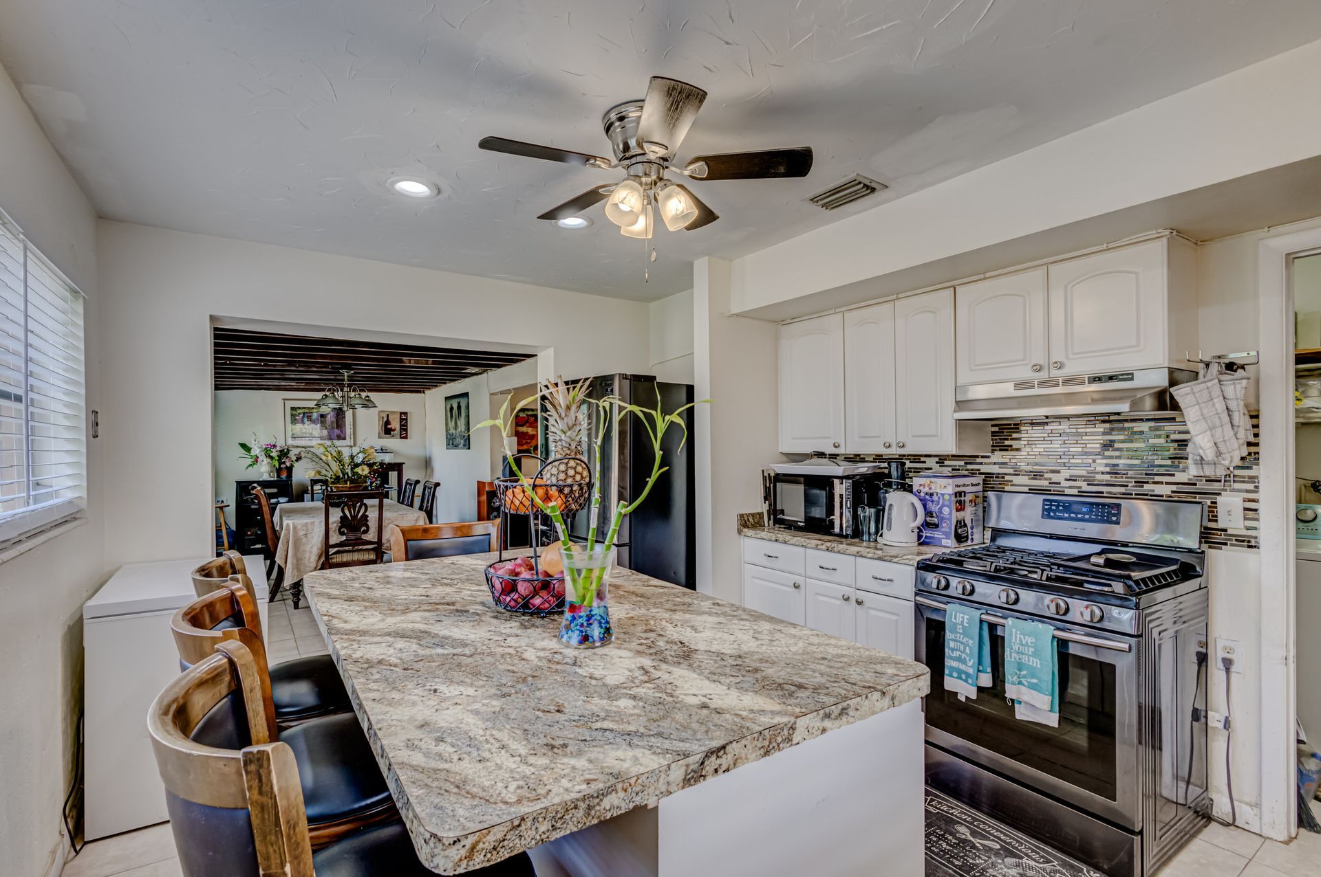 A kitchen with a large island and a ceiling fan.