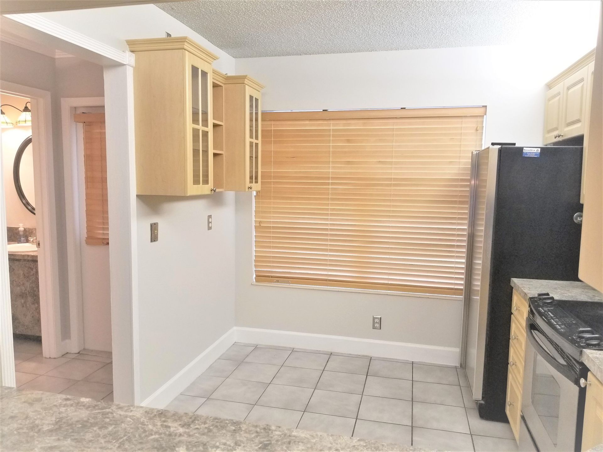 A kitchen with a black refrigerator and a window