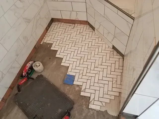 A bathroom with a herringbone pattern on the floor