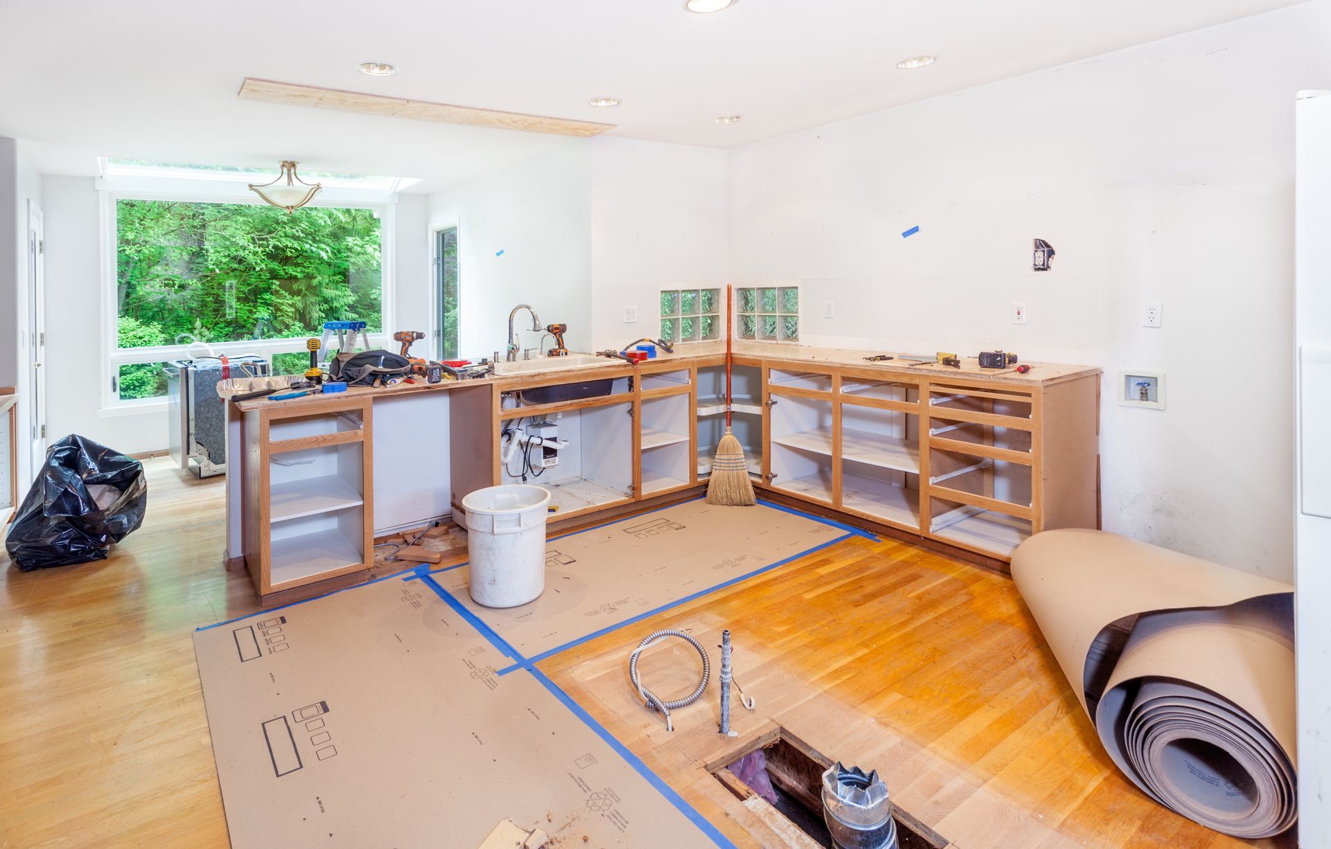 A kitchen under construction with a roll of cardboard on the floor.
