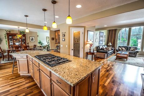 Kitchen with large island, granite countertops, and open view to dining and living areas.