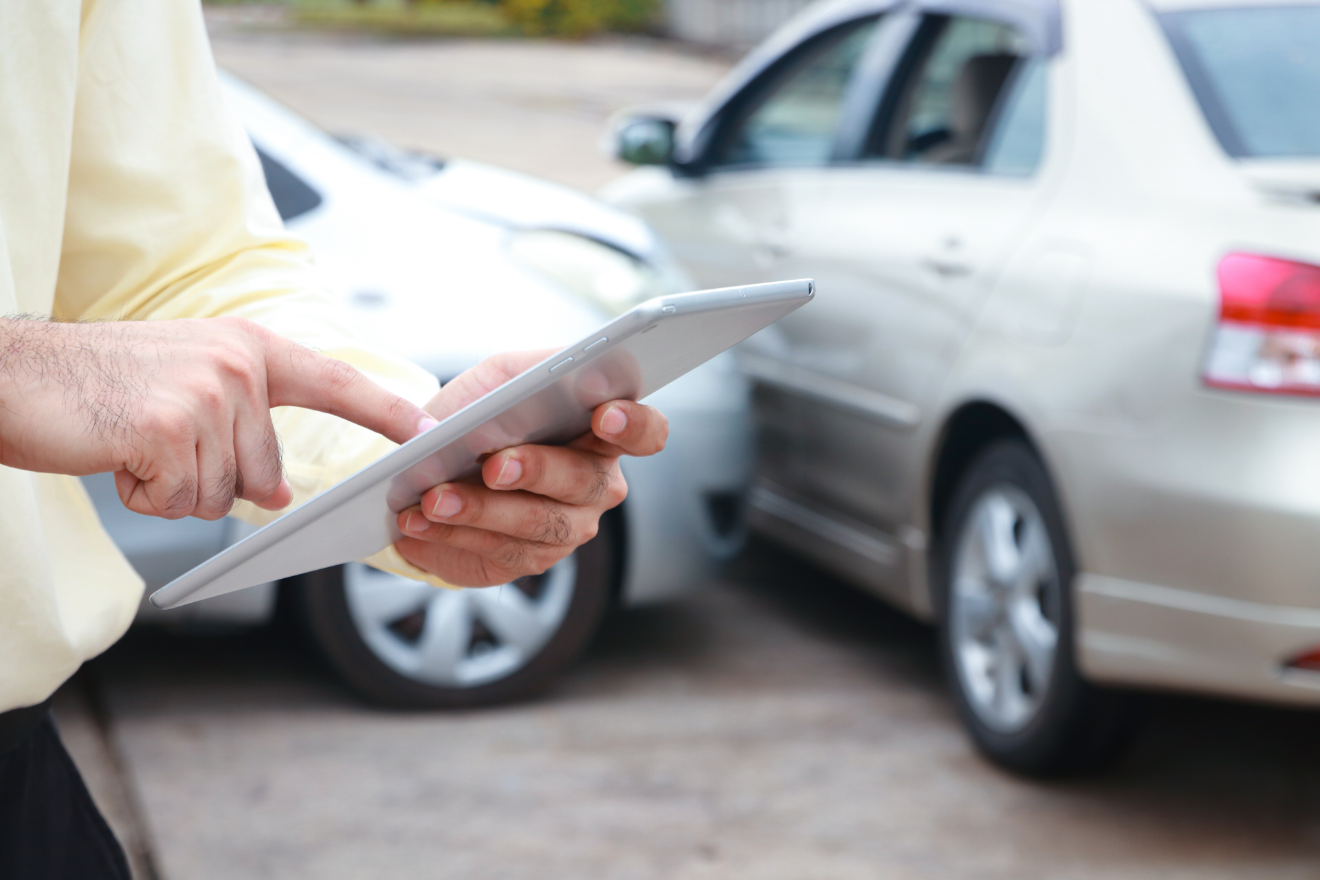 Red car with severe damage to the rear, loaded on a tow truck.