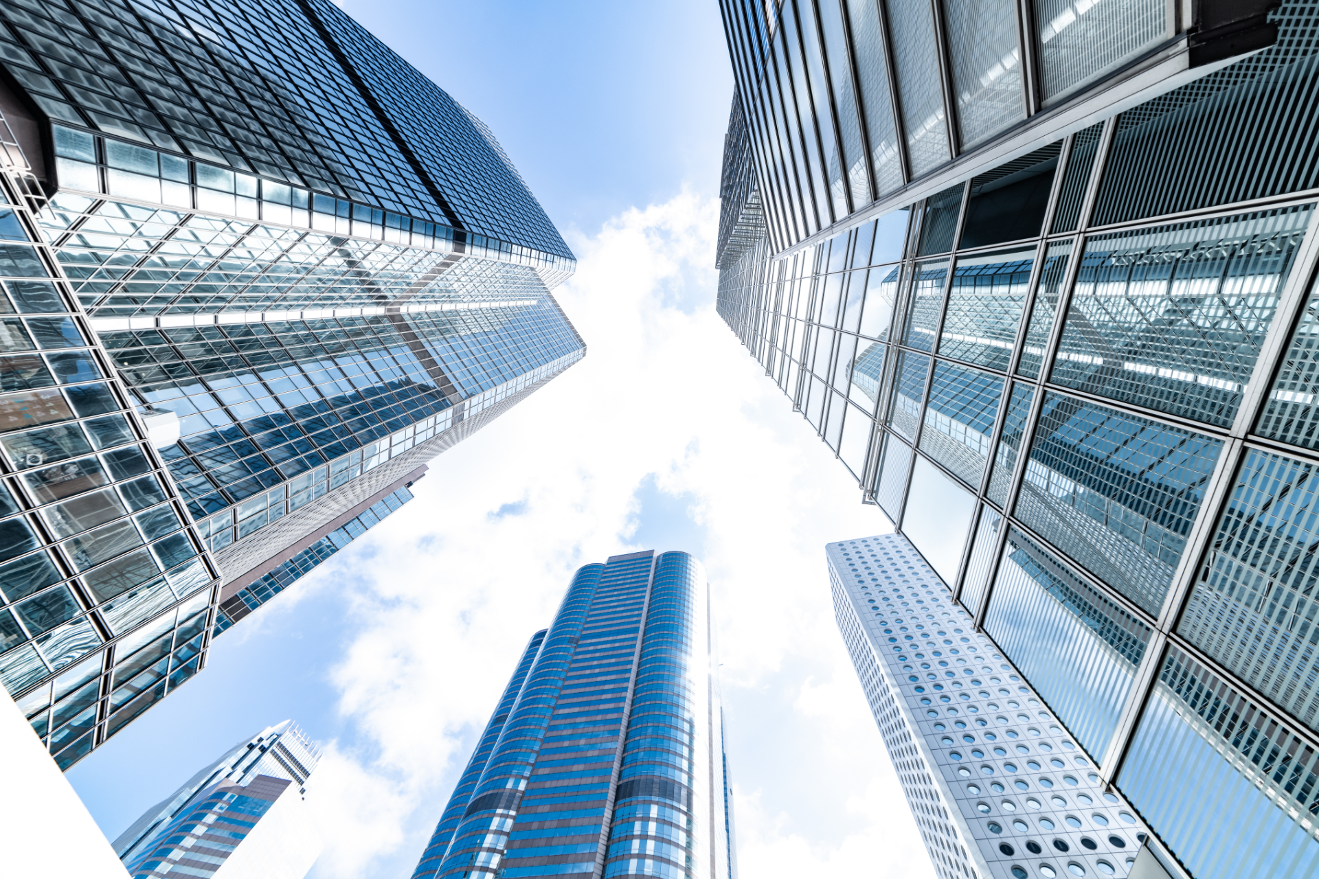 Red car with severe damage to the rear, loaded on a tow truck.