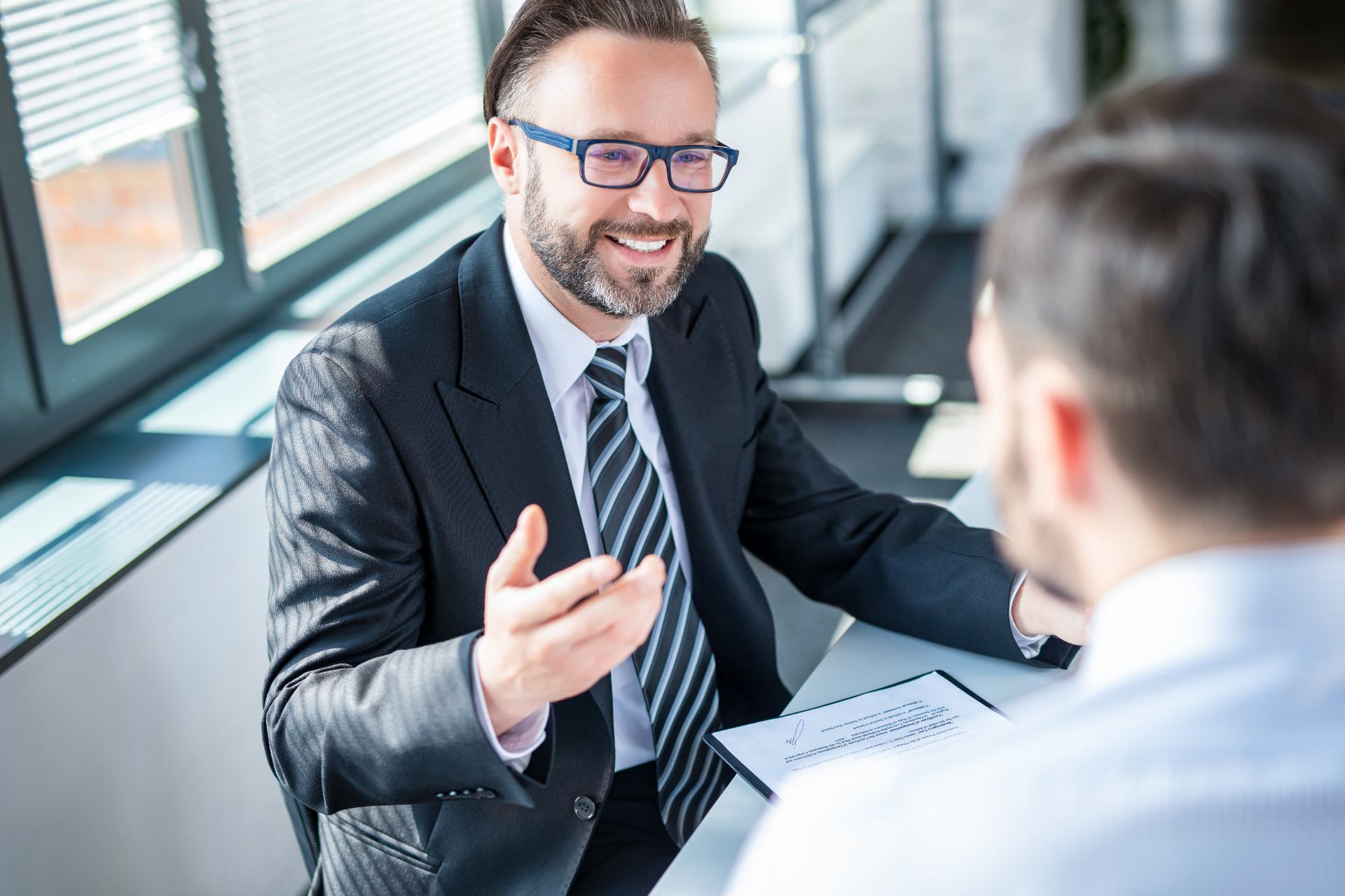 Red car with severe damage to the rear, loaded on a tow truck.