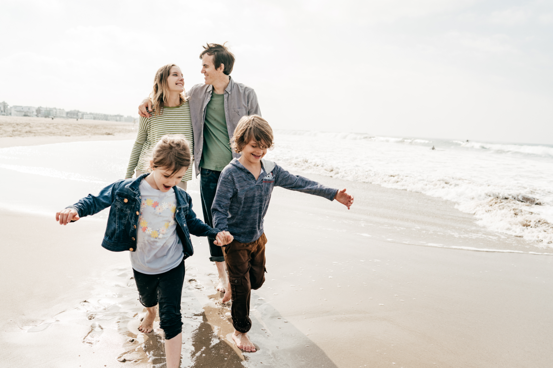 Red car with severe damage to the rear, loaded on a tow truck.