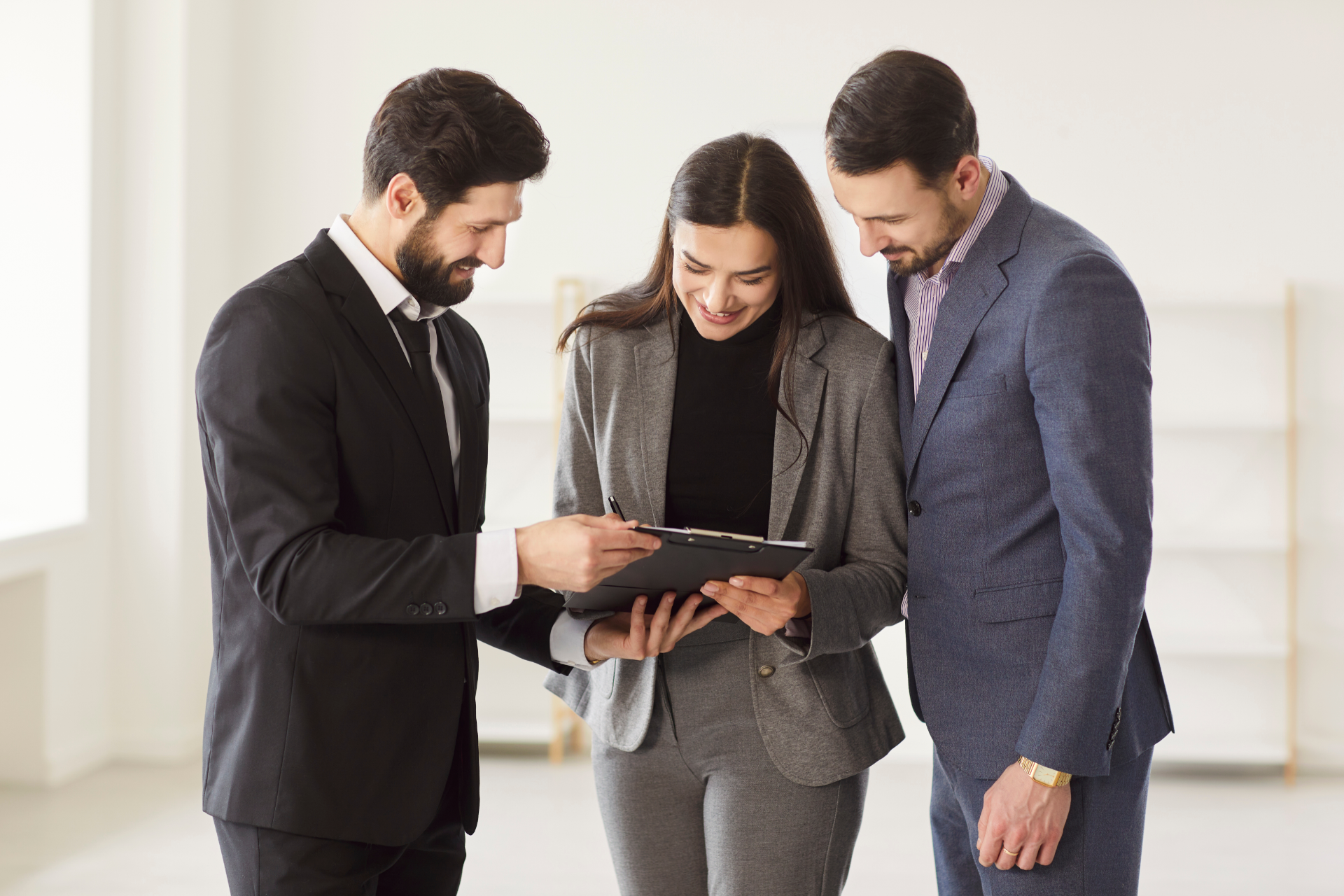 Red car with severe damage to the rear, loaded on a tow truck.