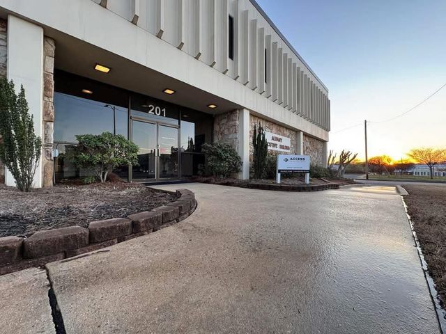 Exterior view of a building with a glass entrance. The number 