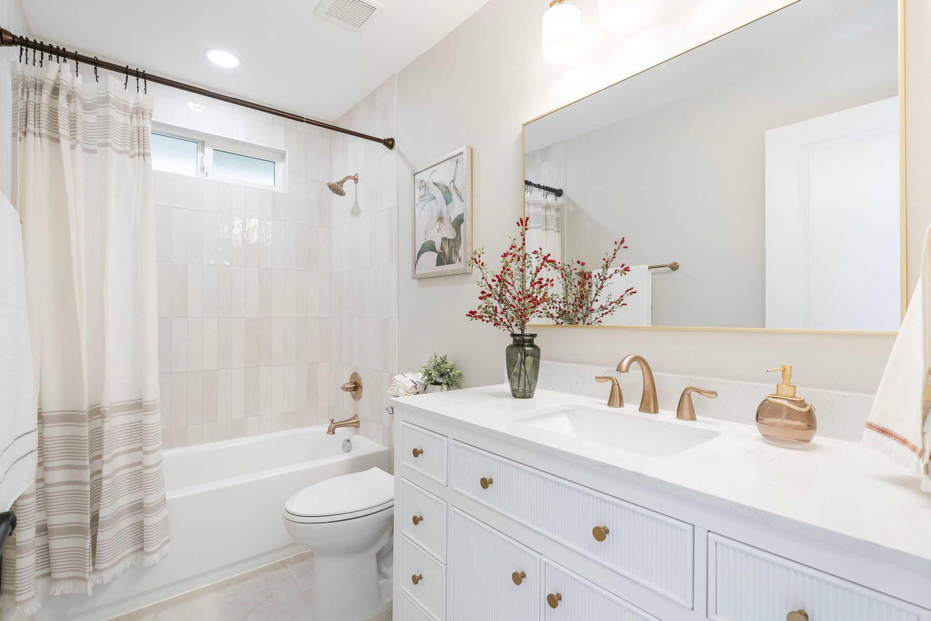 A bathroom with a sink , toilet , shower and mirror.