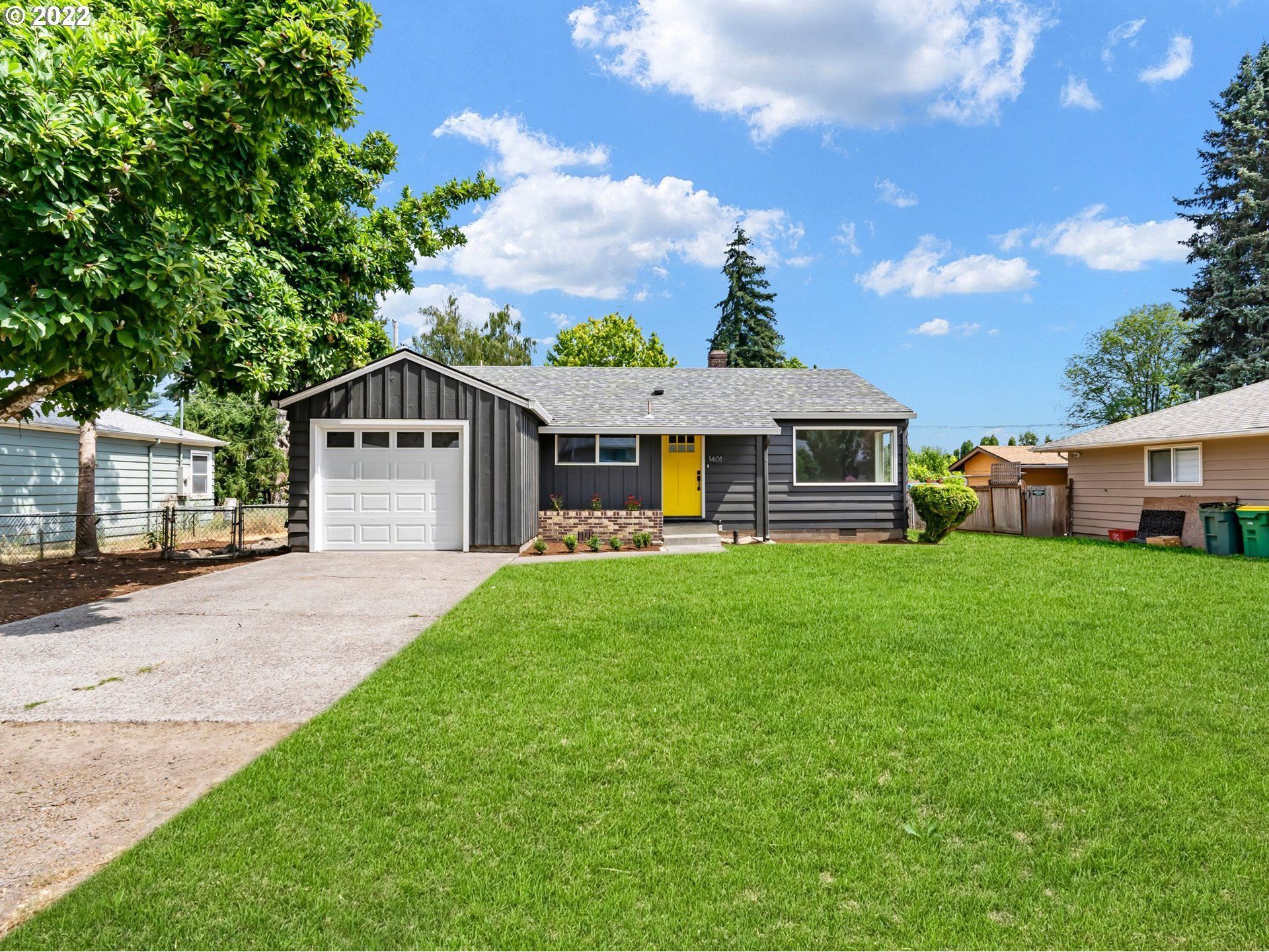 A house with a large lawn in front of it and a garage.