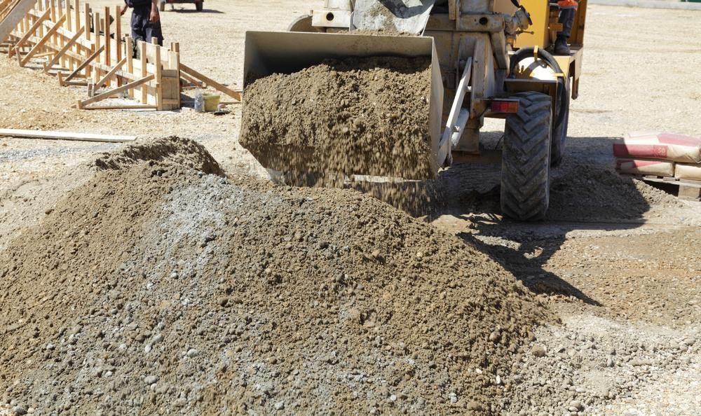 A Bulldozer is Loading Dirt Into a Pile on a Construction Site — Hothams In Mudgee, NSW