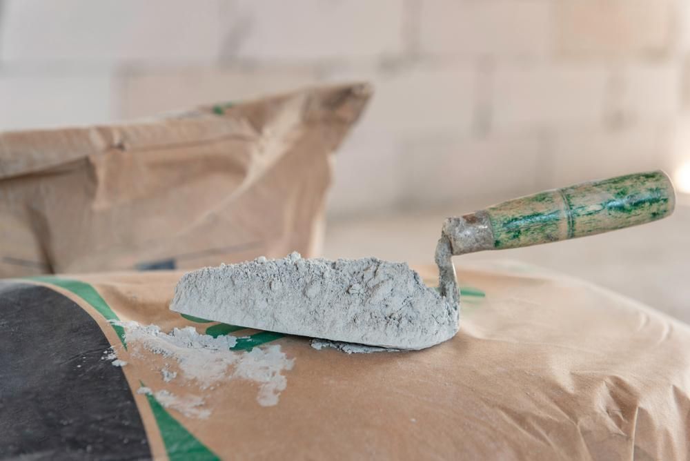 A Trowel is Sitting on Top of a Bag of Cement — Hothams In Dubbo, NSW