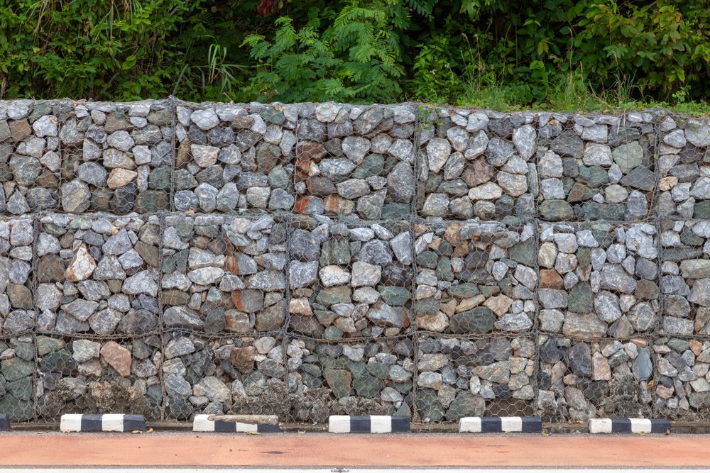 A Stone Wall With a Wooden Bench in Front of It — Hothams In Bathurst, NSW