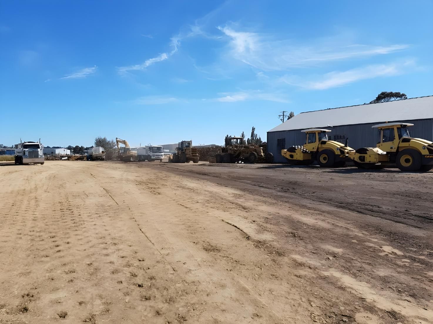 A Row of Construction Vehicles Are Parked in a Dirt Lot — Hothams In Bathurst, NSW