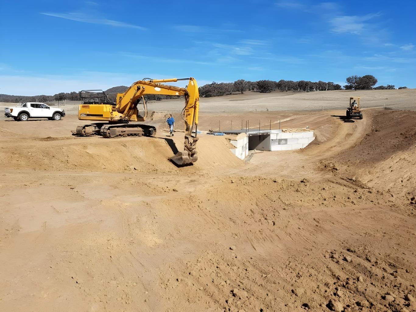 A Excavator is Digging a Hole in the Dirt — Hothams In Bathurst, NSW