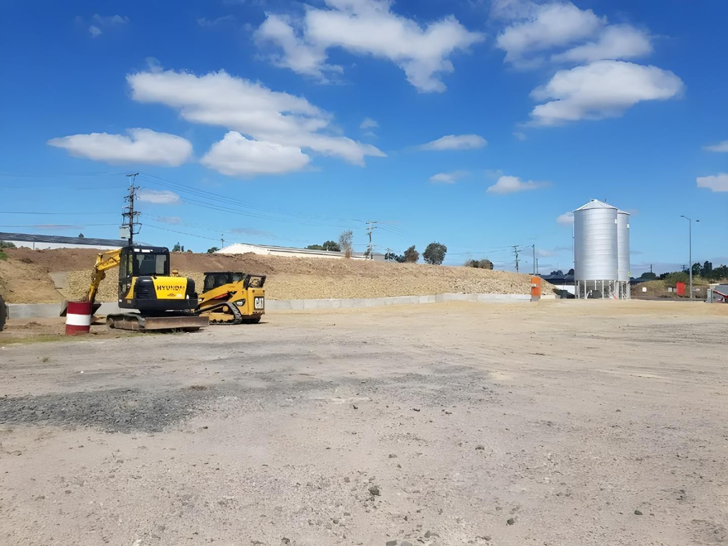 A Big Excavator is Parked in the Middle of a Dirt Field — Hothams In Bathurst, NSW