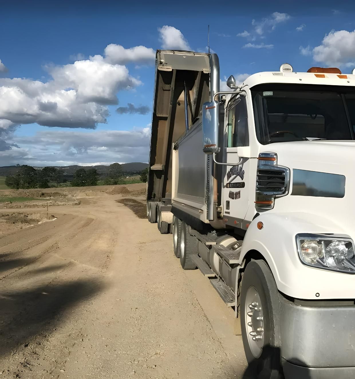 A White Dump Truck is Parked on a Dirt Road — Hothams In Bathurst, NSW