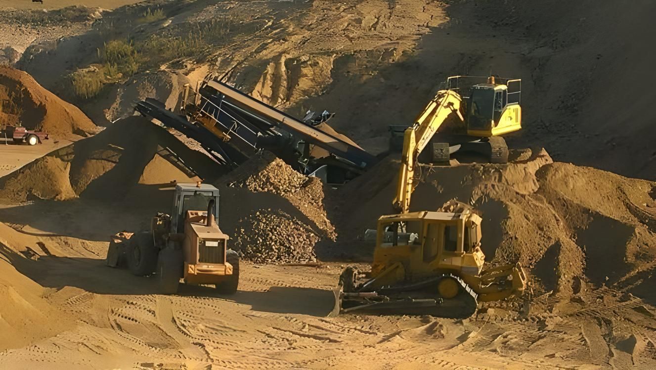 A Yellow Excavator is Loading Sand Into a Dump Truck — Hothams In Bathurst, NSW