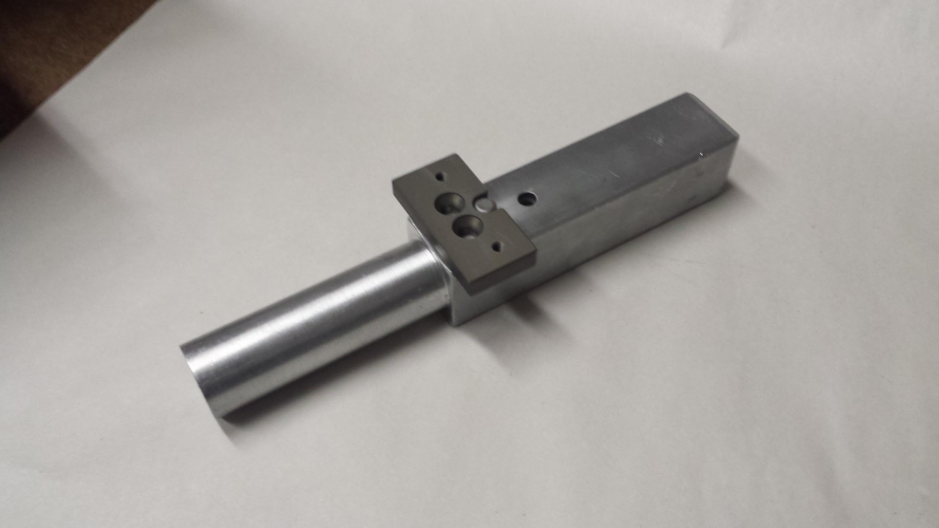 A machine is cutting a piece of metal in a factory.