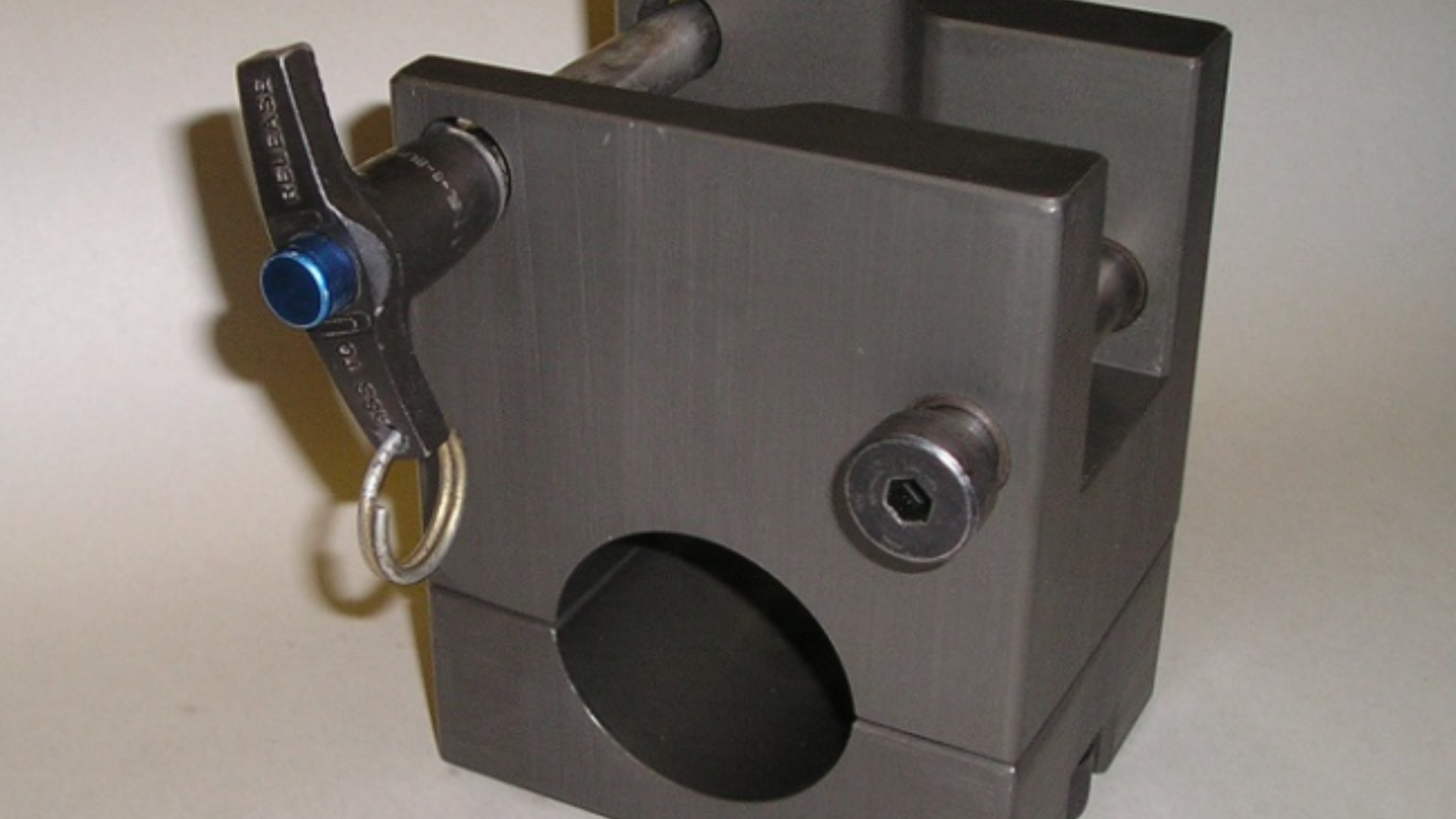 Two scope mounts are sitting on a wooden table.