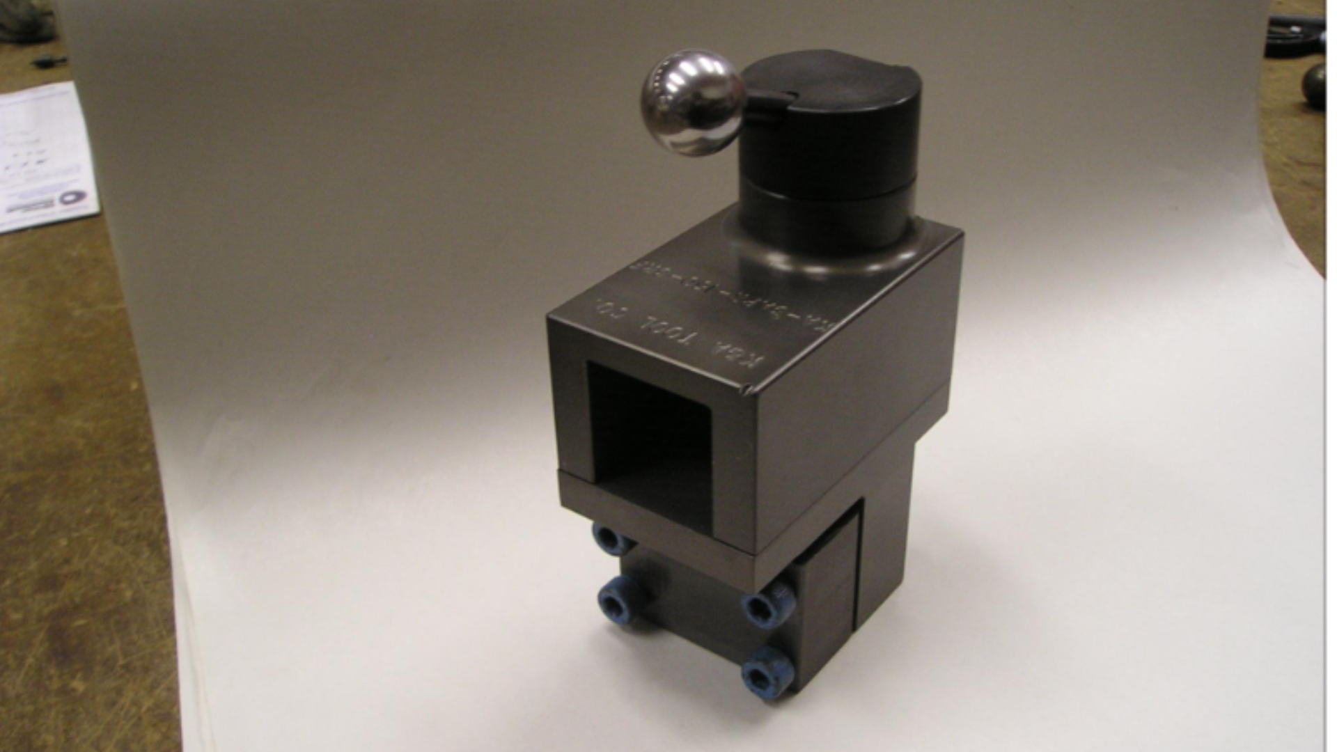 An old radio is sitting on a wooden table next to a hammer and pliers.