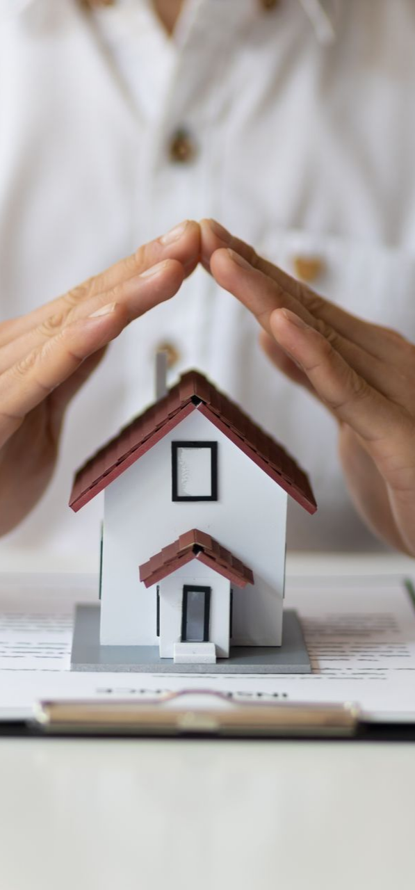 Cropped view of an agent from a local insurance agency, with a contract and a house model. Cropped view of an agent from a local insurance agency, with a contract and a house model.
