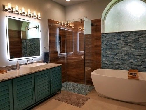 a bathroom with a tub , sink , mirror and walk in shower .