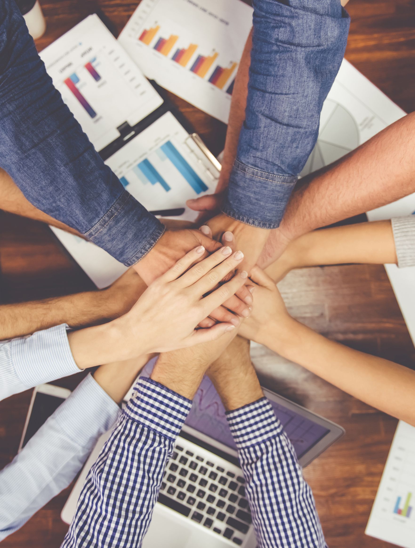 team members putting hands together to celebrate teamwork at Stonehenge Homes