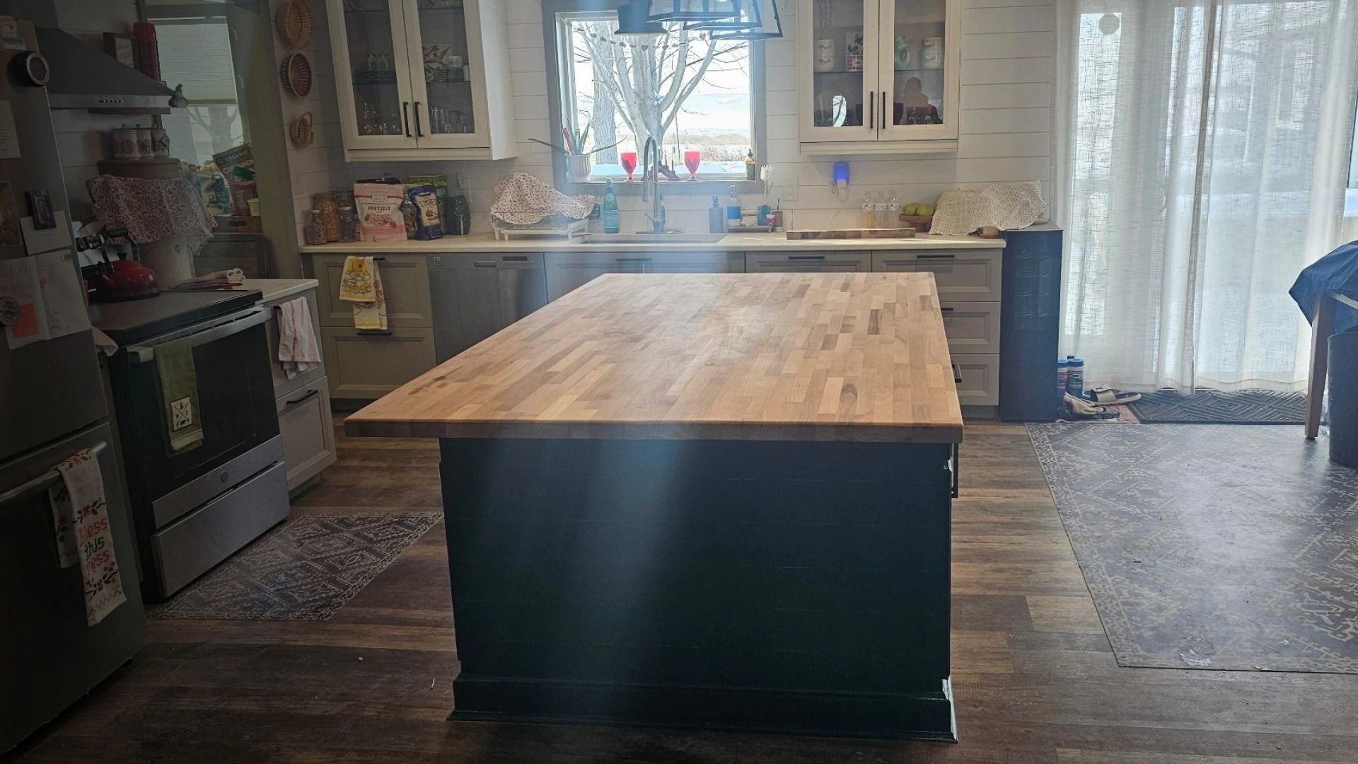 A kitchen with a large wooden island in the middle of it.