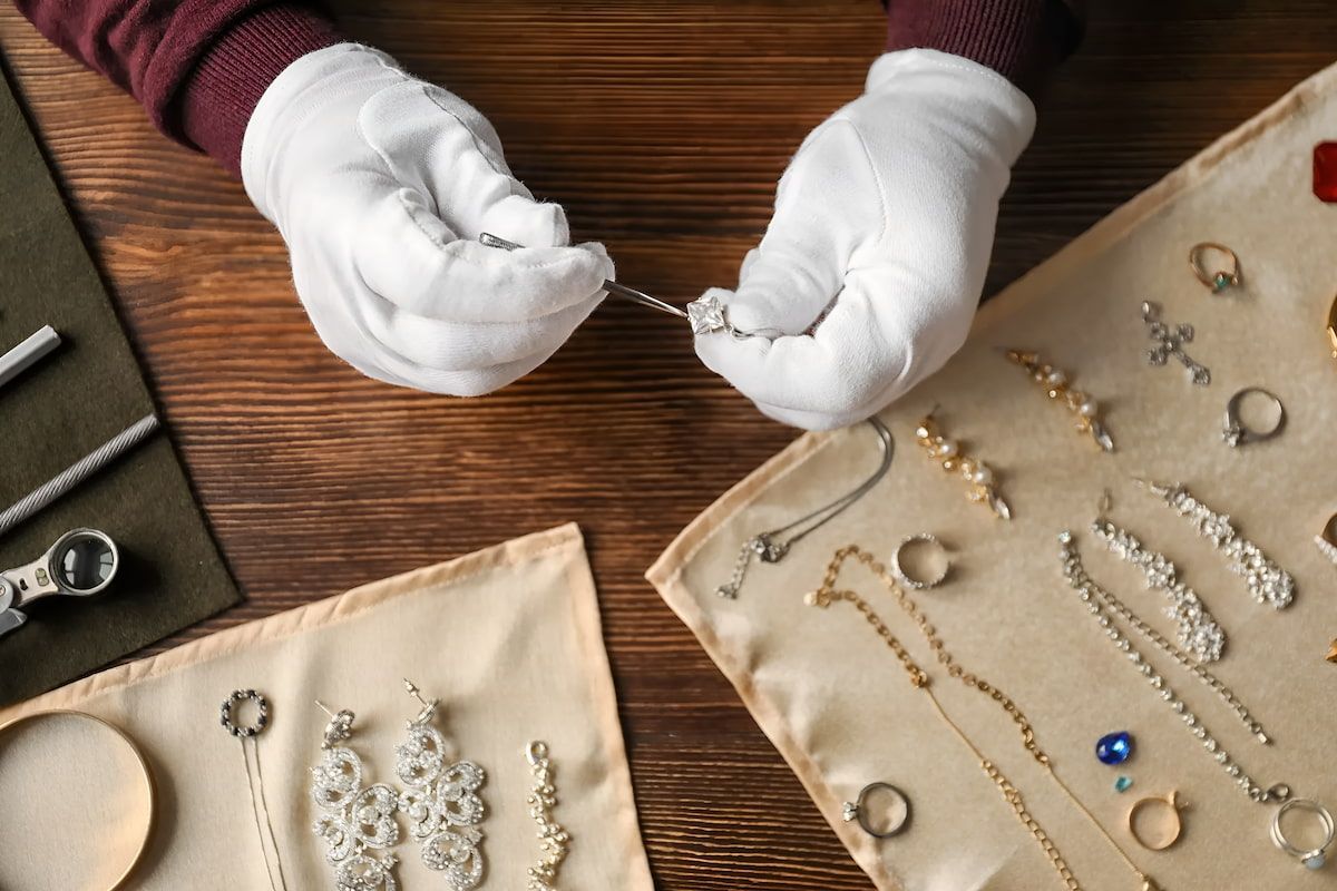 Hands in White Gloves Examining Jewelry — Chris Williams Retail & Manufacturing Jewellers in Wanguri, NT