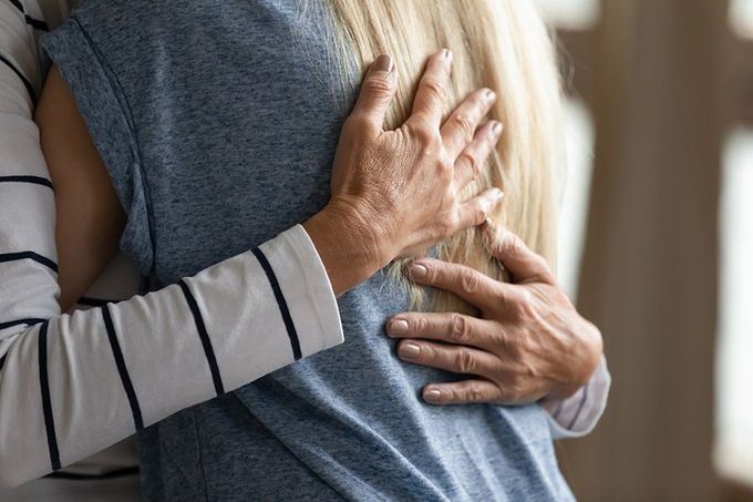 A woman is hugging a man in a blue shirt.