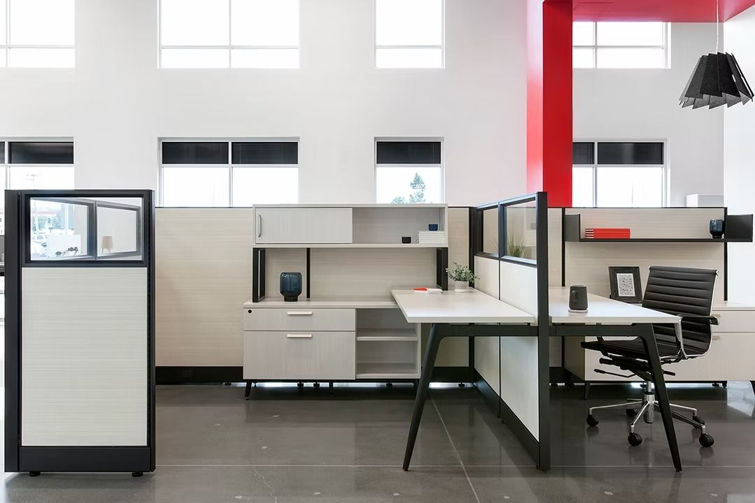 A cubicle with a desk and a chair in it