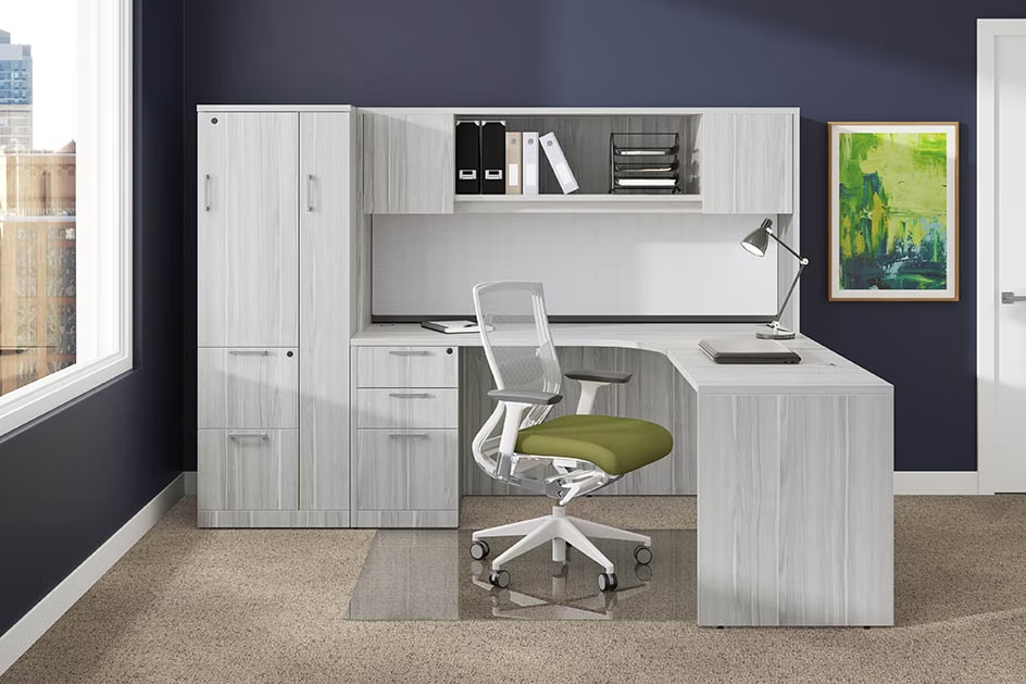 A white desk with a green chair in a room with blue walls.