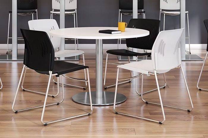 A round table with four chairs around it in a room.