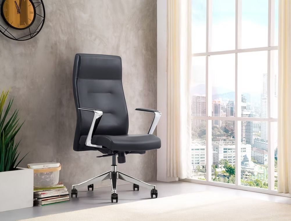 A black office chair is sitting in front of a window in a room.
