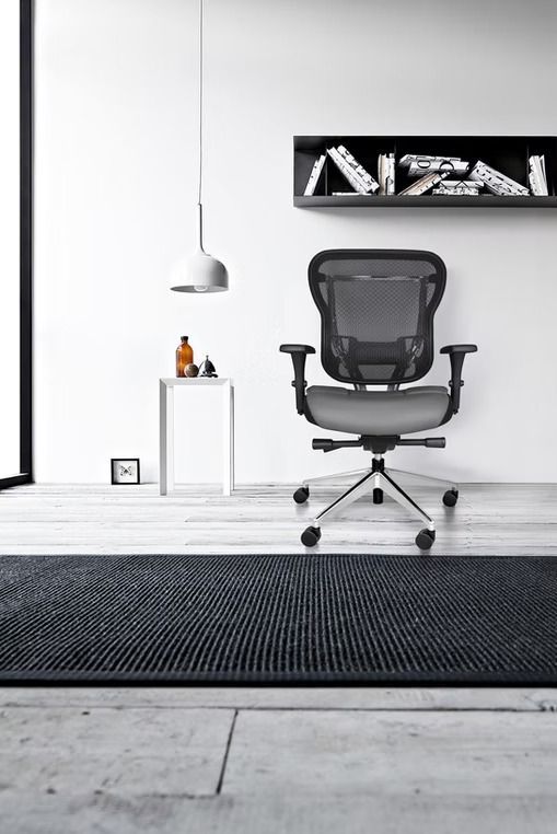 A black and white photo of an office chair in a room.