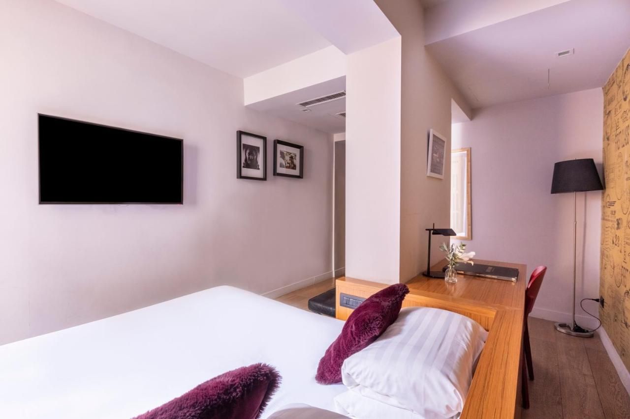 una camera d' albergo con un letto e una scrivania