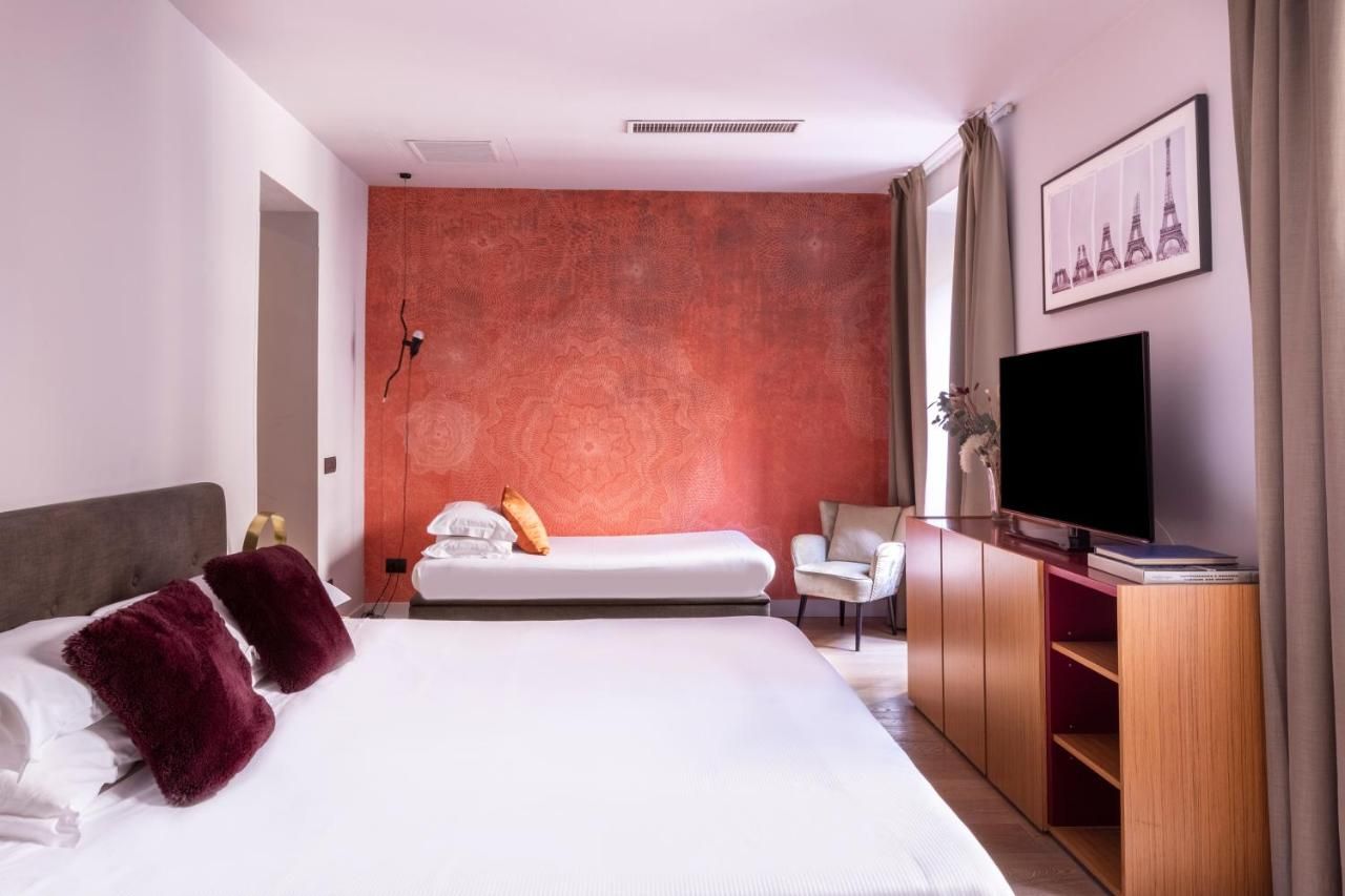 una camera d' albergo con due letti e un televisore