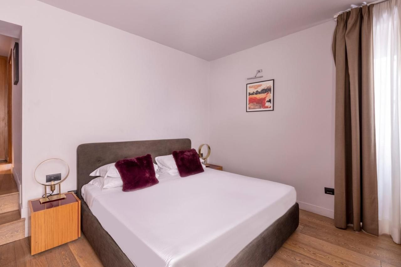 a bedroom with a white bed and two purple pillows