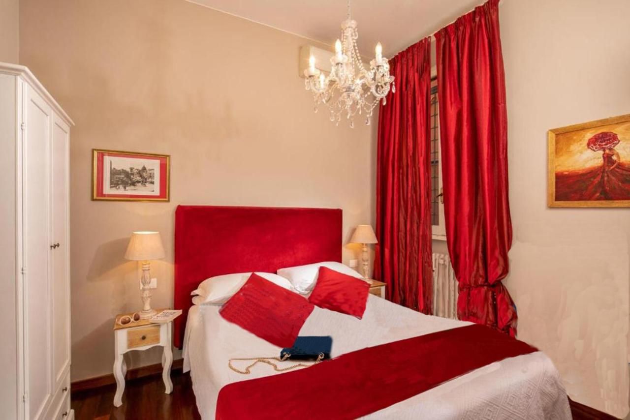 una camera da letto con un letto rosso e un lampadario