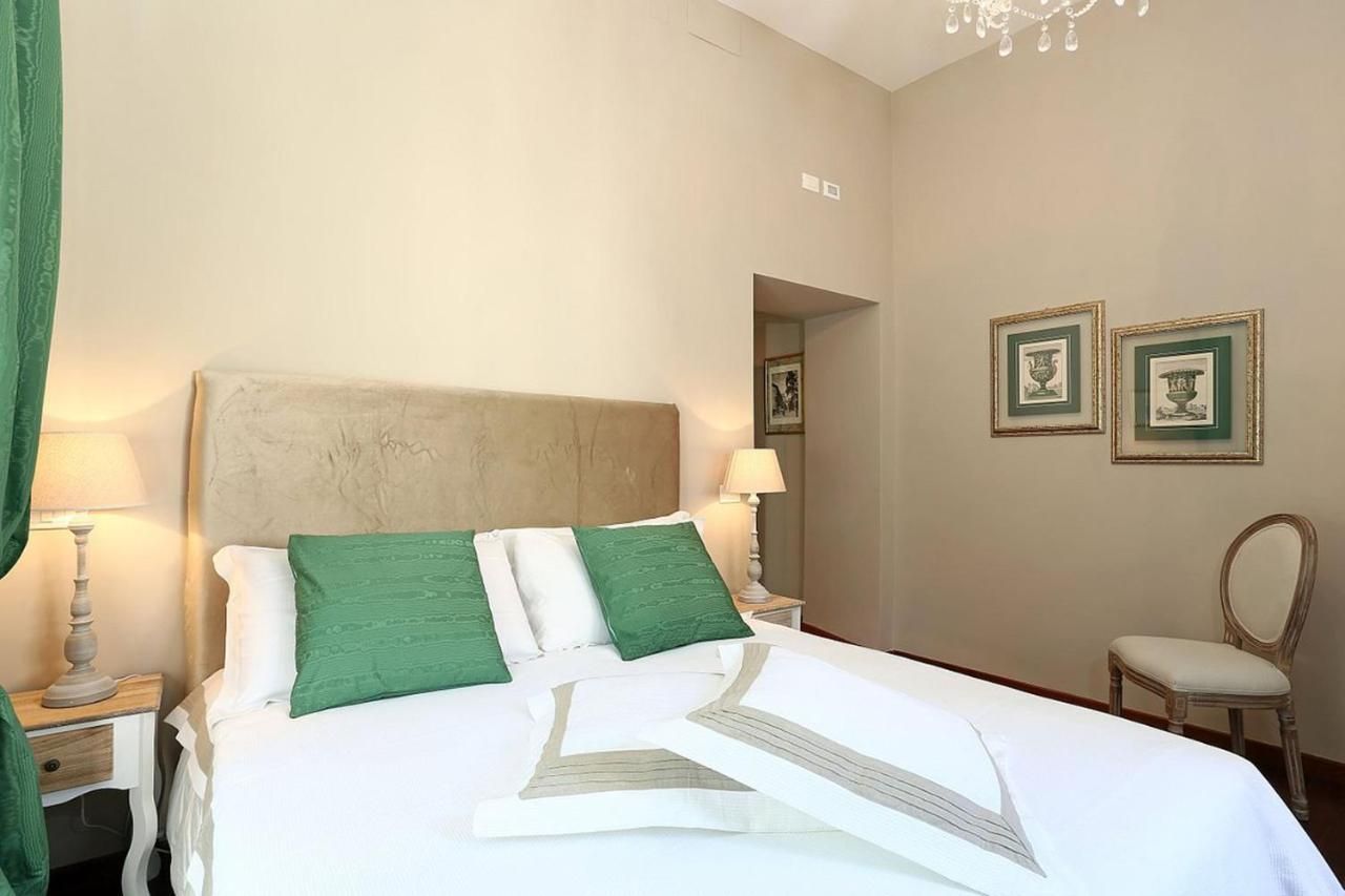 una camera da letto con un letto bianco e cuscini verdi