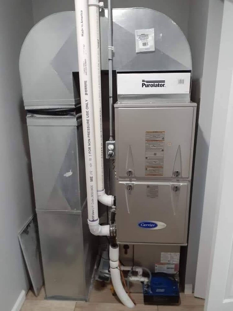 A stainless steel air conditioner is sitting in a corner of a room.