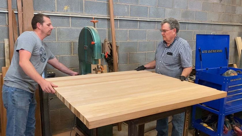 two man cutting a wood