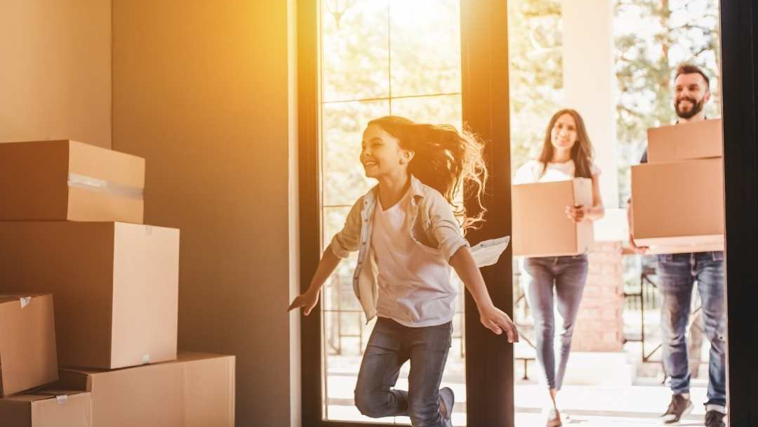 Kid running to her new house with parents