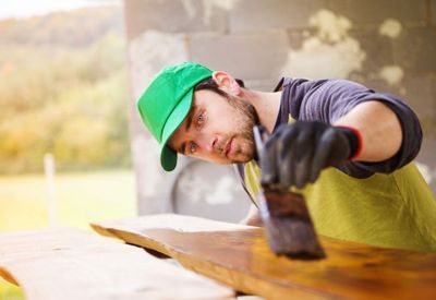 Handyman varnishing wood planks